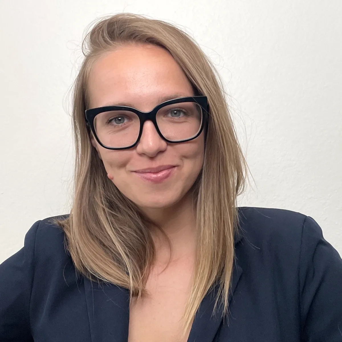 Portrait of Liudmila Rukavishnikova, co-founder of Decode Nation, smiling, with glasses and long blonde hair
