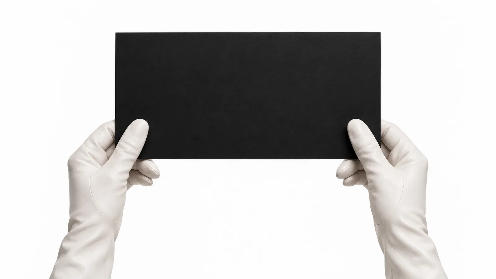 Two hands in white gloves holding up a large black card against a white backdrop